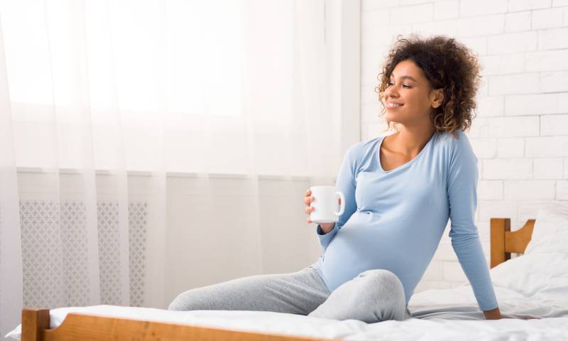 Femme enceinte tenant une tasse de café 