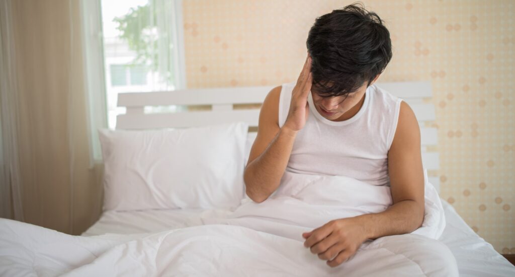 Homme ayant du mal à dormir sur son lit