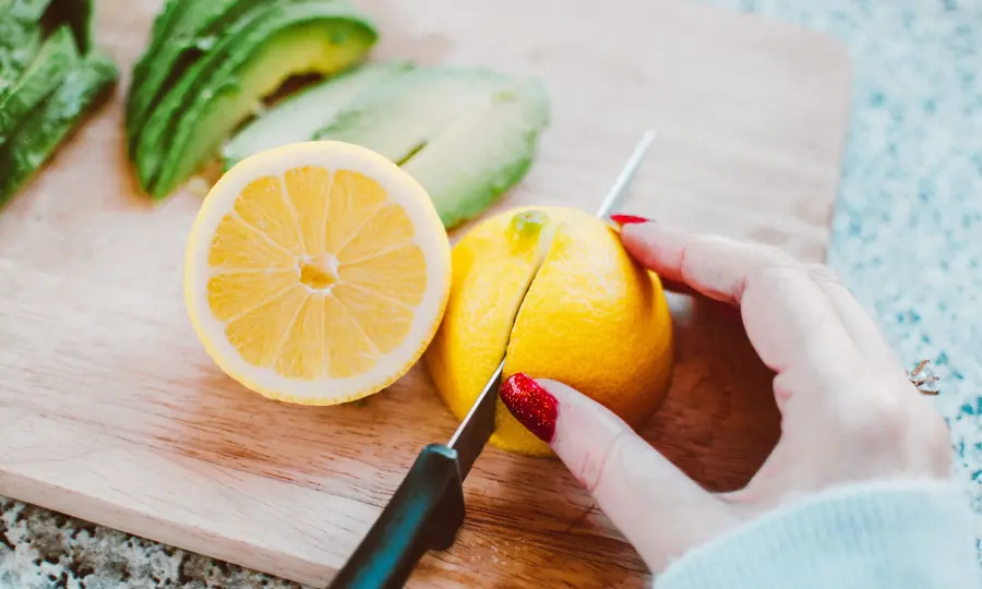 Femme découpant du citron sur une planche