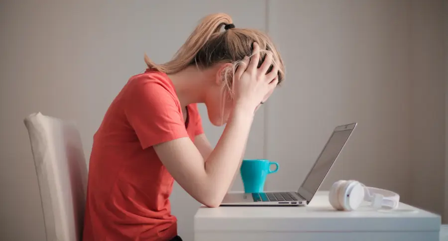 Femme se sentant stressée devant son ordi