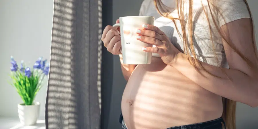 Une femme enceinte avec une tasse à la main