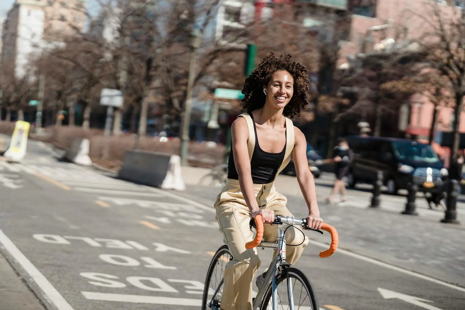 A Smiling Woman Riding a Bicycle in the City