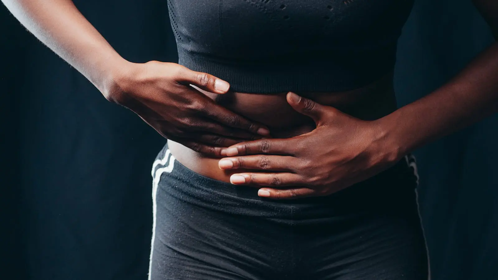 Person Wearing Black Active Wear Holding Her Tummy