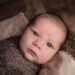 baby in brown swaddle