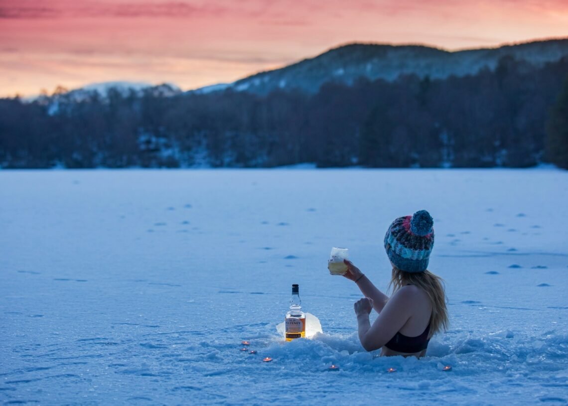 woman in black bikini top holding clear plastic bottle on water