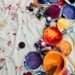 assorted-color paints and paintbrushes on white tarp