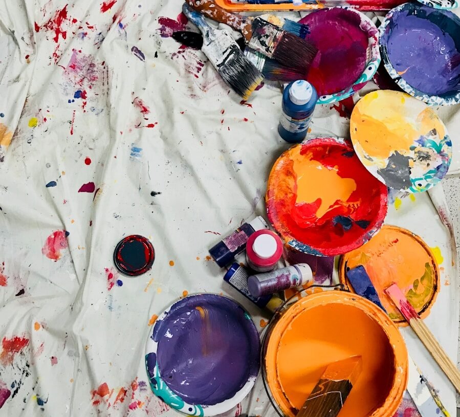 Body art et les effets thérapeutiques pour le mental : l'expression corporelle favorise le bien-être psychologique 1 assorted-color paints and paintbrushes on white tarp