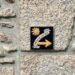 a sign on a stone wall pointing to the right