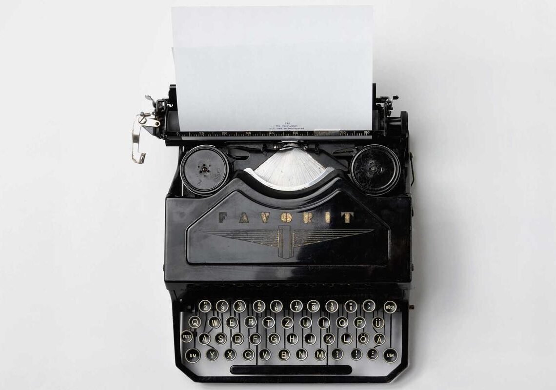 Machine à écrire ancienne avec une feuille blanche, symbole des mots retenus — angines répétition symbolique