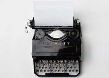 Machine à écrire ancienne avec une feuille blanche, symbole des mots retenus — angines répétition symbolique