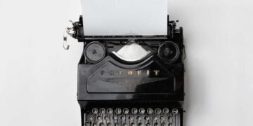 Machine à écrire ancienne avec une feuille blanche, symbole des mots retenus — angines répétition symbolique