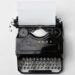 Angines répétition symbolique : mots avalés 7 Machine à écrire ancienne avec une feuille blanche, symbole des mots retenus — angines répétition symbolique