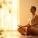 Méditation transcendantale en position lotus, lumière dorée — méditation transcendantale bienfaits