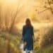 Rupture amoureuse : guérir et se reconstruire 7 Femme marchant seule dans la nature après une rupture amoureuse, lumière dorée apaisante — rupture amoureuse comment s'en remettre