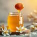 Miel de Manuka : bienfaits et usages 7 Pot de miel de Manuka avec rayon de miel et fleurs blanches — miel de Manuka bienfaits