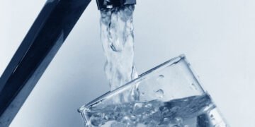 Verre rempli d'eau claire directement au robinet de cuisine - qualité de l'eau du robinet en France