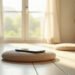 Applications de méditation : ce qu’elles changent vraiment 7 Un smartphone posé sur un coussin de méditation vide dans une pièce ensoleillée : applications de méditation