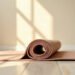Pilates et ostéoporose : les mouvements à modifier 7 Tapis de Pilates à demi déroulé, la spirale au premier plan dans la lumière du matin, pilates et ostéoporose